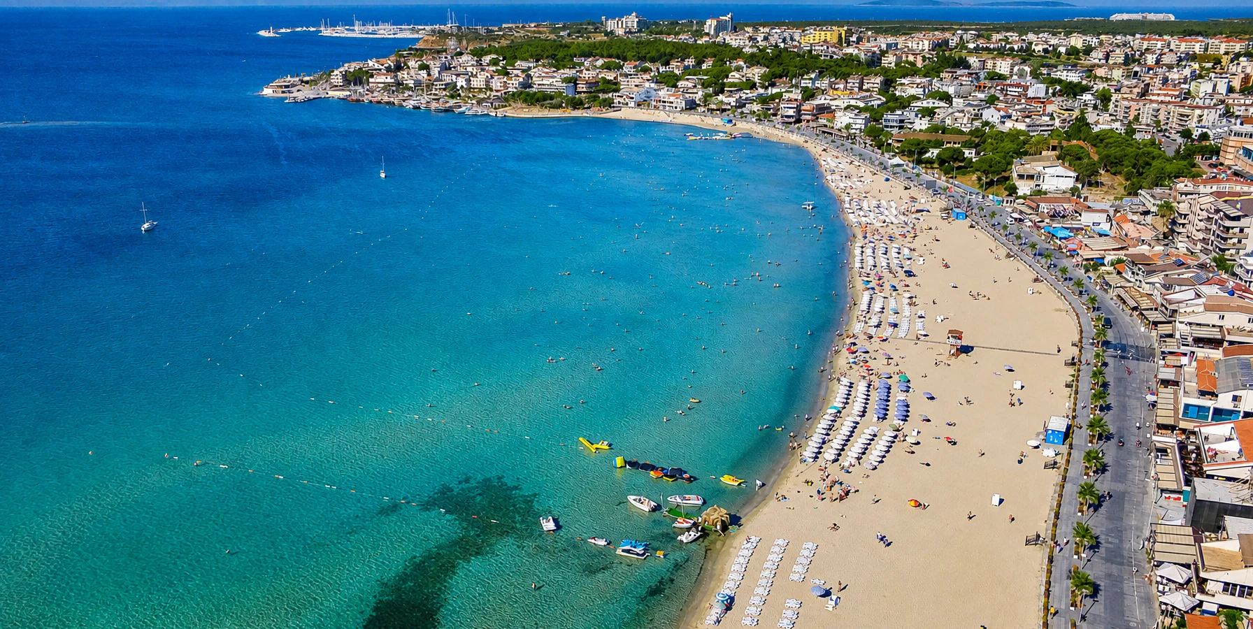 Golden sandy shoreline and turquoise Aegean water at Altinkum Beach in Didim