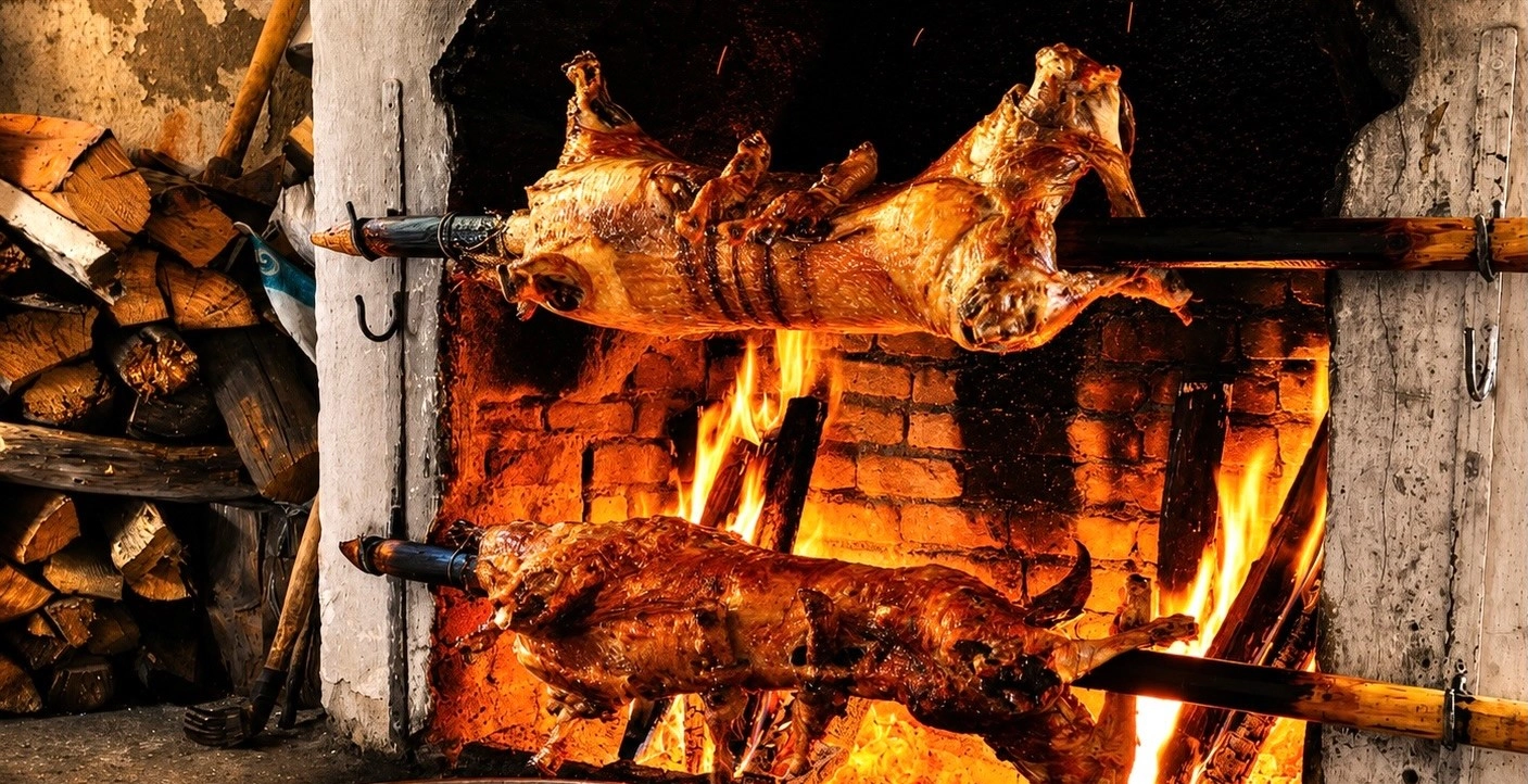 Traditional Olukbaşı Oğlak Çevirme Kebabı, whole young goat roasted on a horizontal spit beside a wood fire in Bozdoğan, Aydın