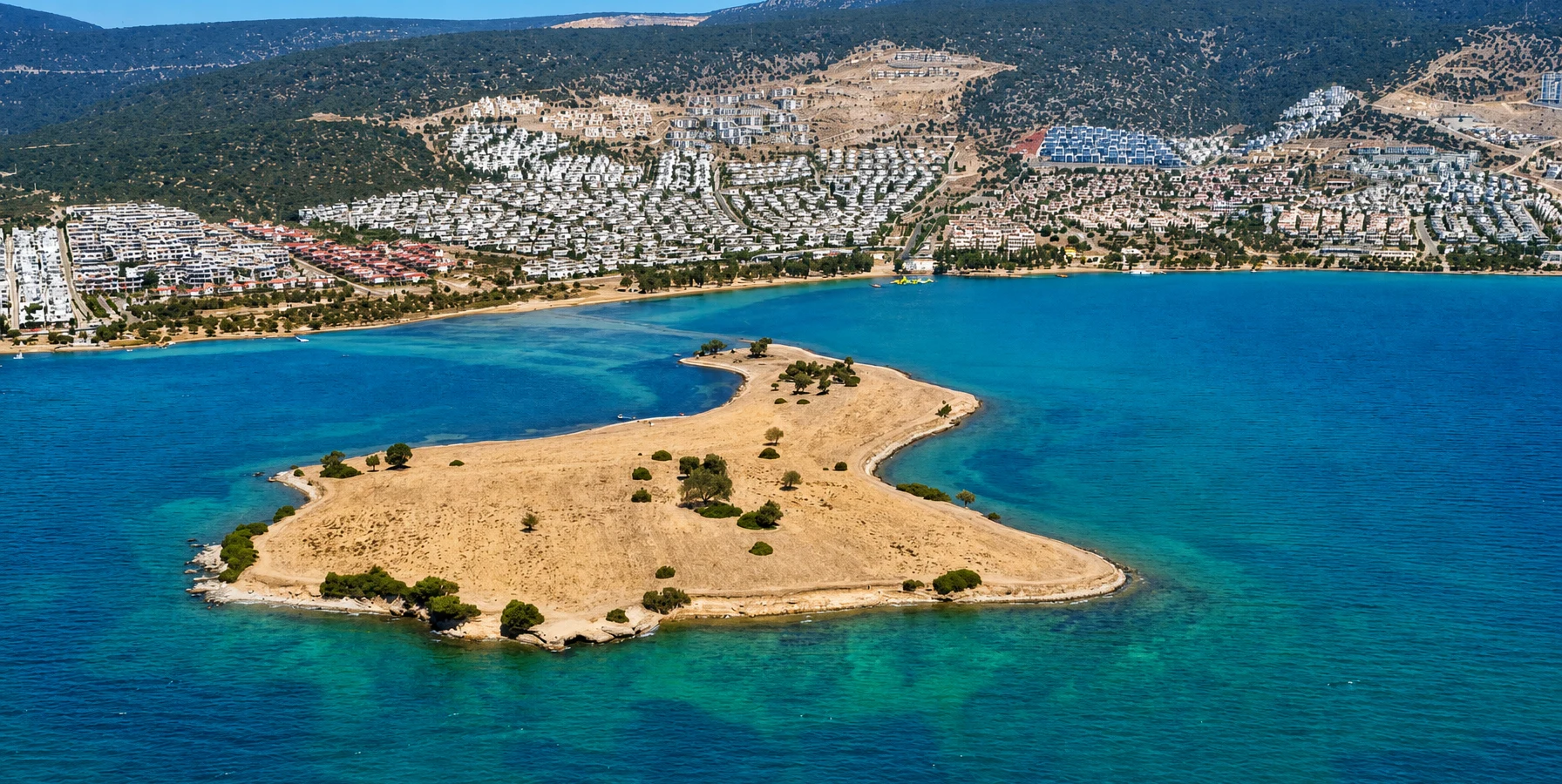 Sapli Ada island with a narrow natural passage through turquoise Aegean water near Akbuk Didim